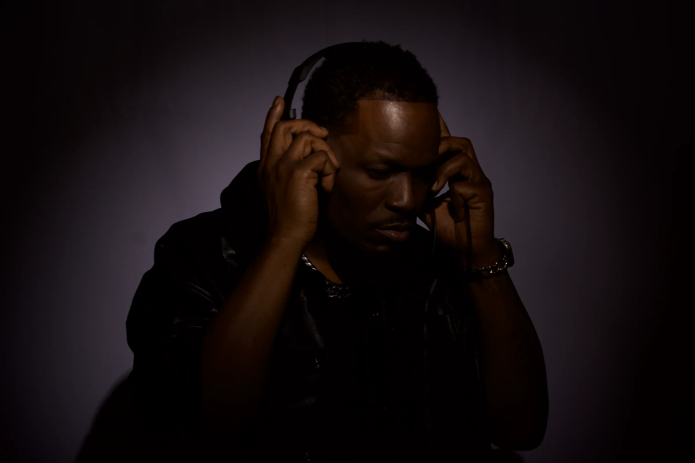 Music creator listening closely through studio headphones